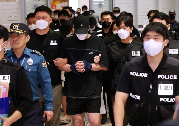 한국 경찰이 10월 18일 인천국제공항에서 온라인 사기 혐의로 캄보디아에서 추방된 시민들을 호송하고 있다. 사진: AFP